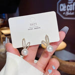 Pearl bunny stud earrings on display card — pair view